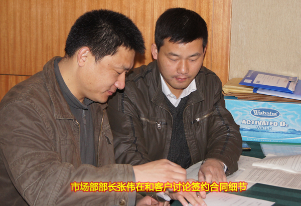 市场部部长张伟在和客户讨论签约合同细节.jpg